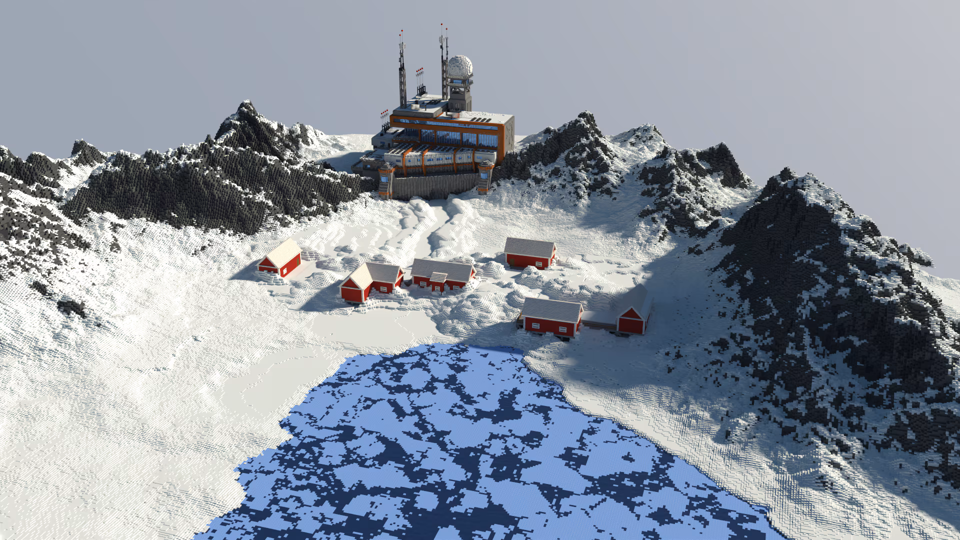 Image of an abandoned building that looks like it could be a research facility, surrounded by snowy mountains, with a few red barn-like buildings in the front flanked by some icy water