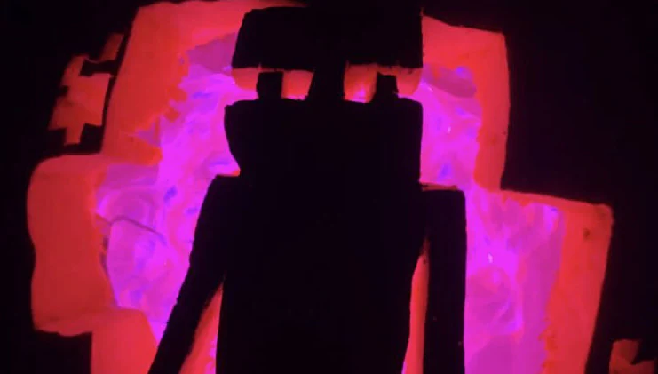 Photo of a pumpkin carved into a jack-o-lantern with an image of an enderman and a glowing pinkish purple light coming from the inside. 