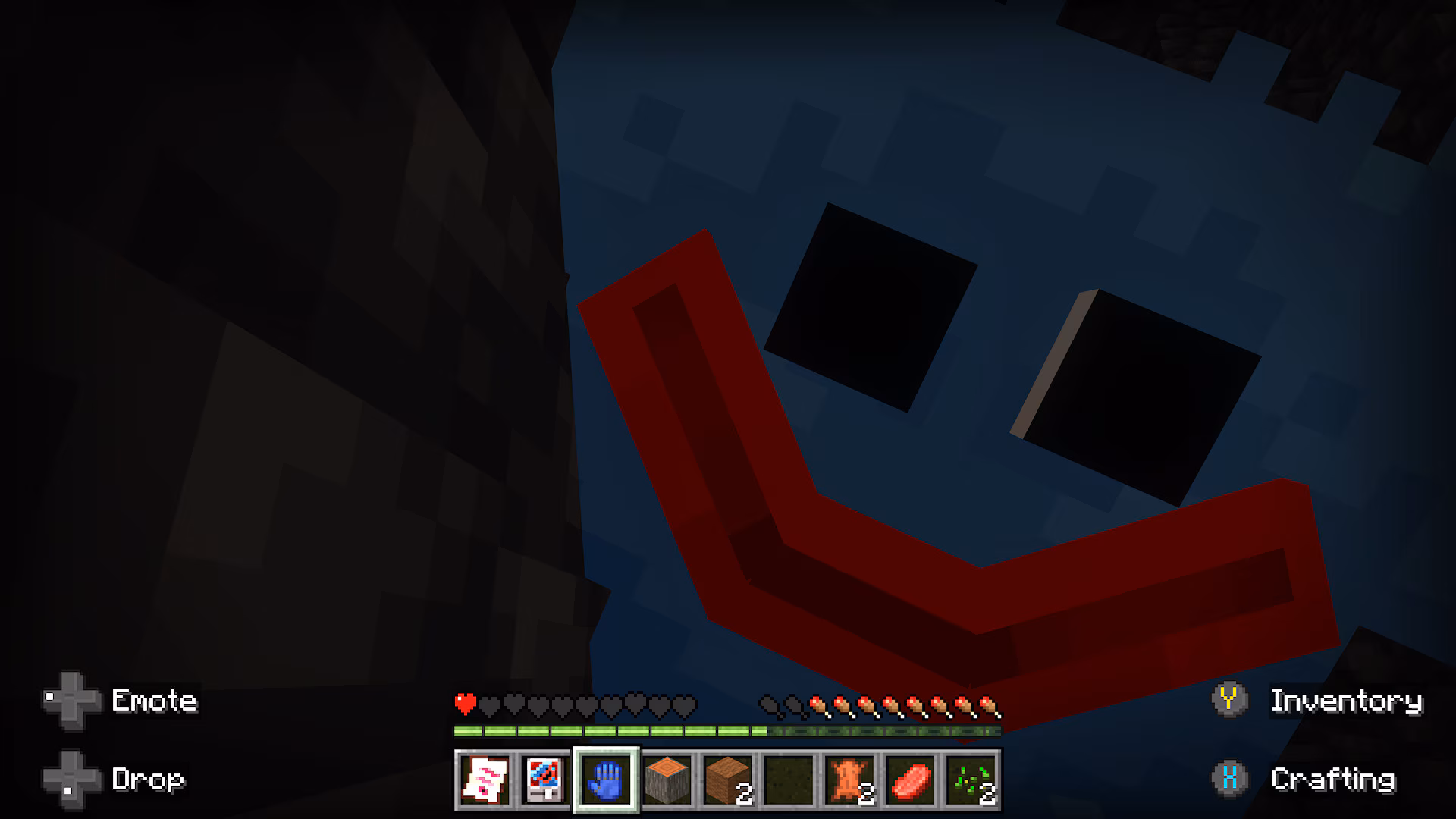 A screenshot of a blue creature peeking from behind some blocks