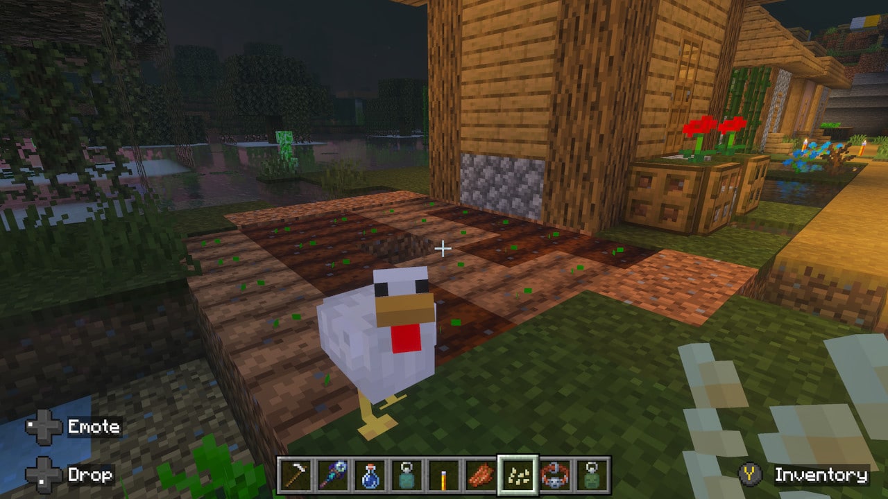 A chicken stands on tilled soil in a nighttime farm setting, with crops growing and a wooden house nearby. The player holds seeds.