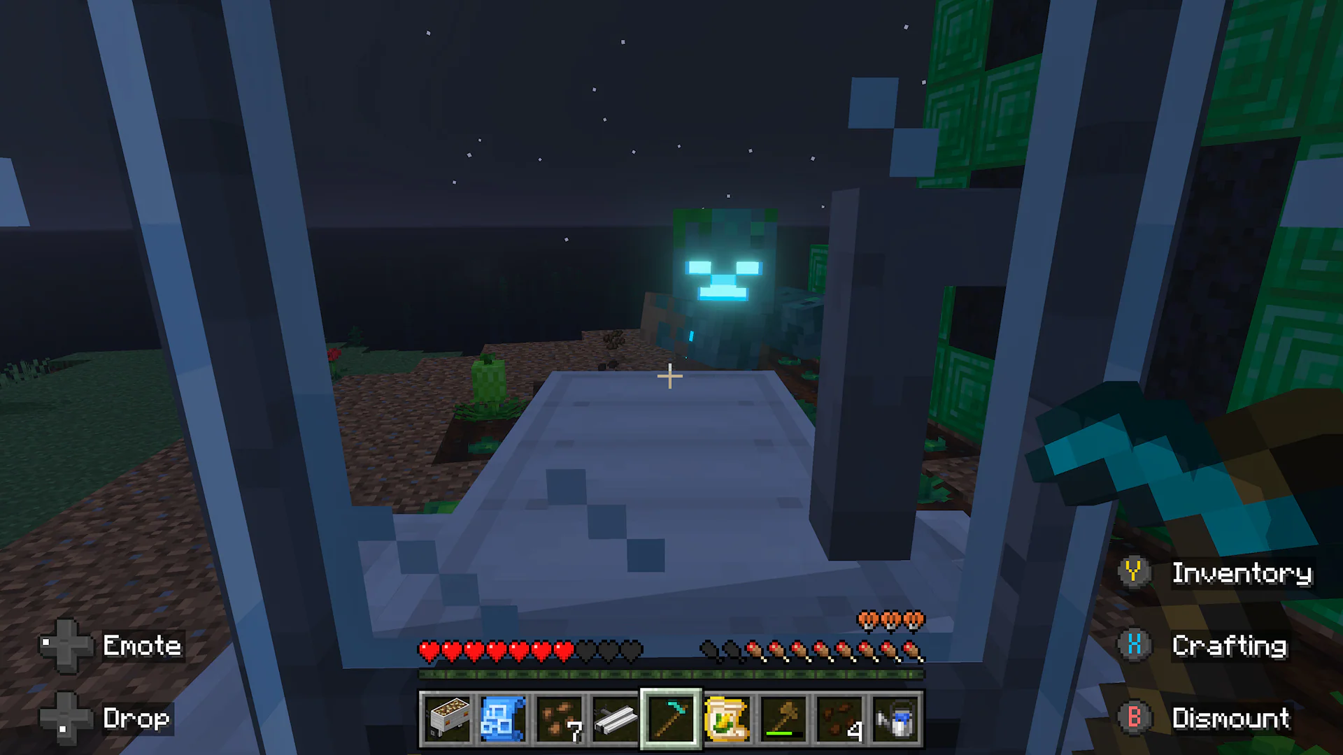Viewed from inside a tractor at night, a player faces a glowing hostile mob near crops and a green block structure.