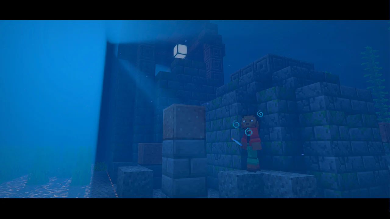 Underwater ruins built from mossy stone bricks with a glowing sea lantern at the top. A Minecraft character in red and green gear stands on the structure holding a sword, surrounded by rising air bubbles in the deep blue ocean.