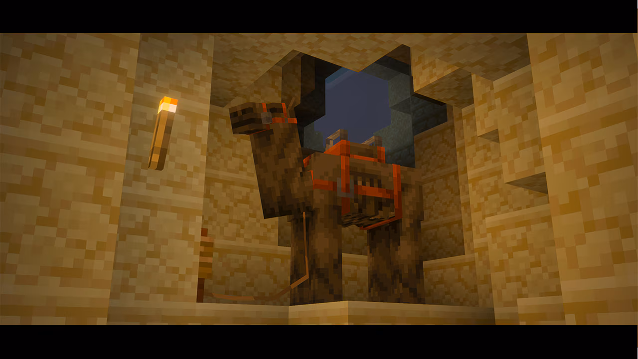 Minecraft camel with a red saddle stands inside a sandstone cave, lit by a torch on the wall. A square opening above reveals the night sky, adding depth to the scene.