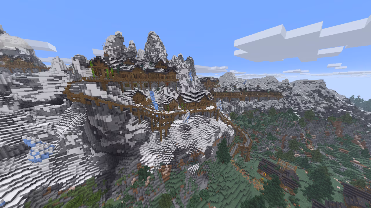 A group of houses built on top of a snowy mountain range.