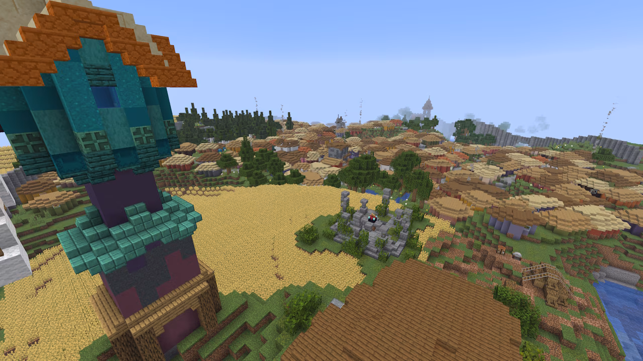 A screenshot in Minecraft, depicting a tall tower that overlooks a large village of huts.