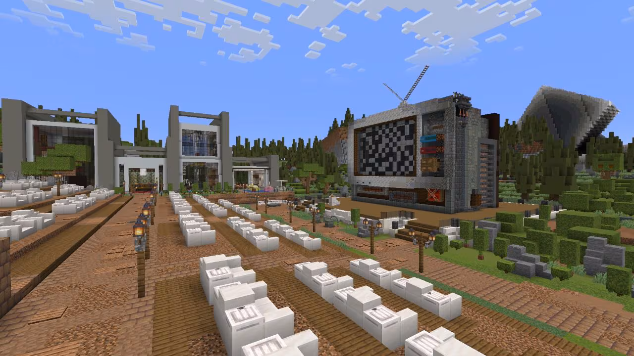 Outdoor venue with seating rows and giant screen stage.